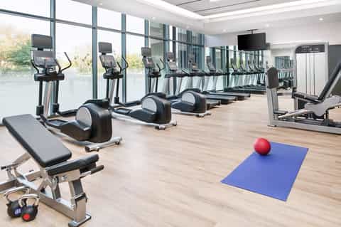 State-of-the-art fitness center with exercise bikes, treadmills, dumbbells, and large windows with natural views