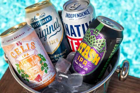 Selection of craft beers in ice bucket with pool in background