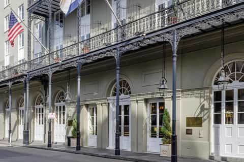 Historic building facade with ornate black iron balconies and white doors