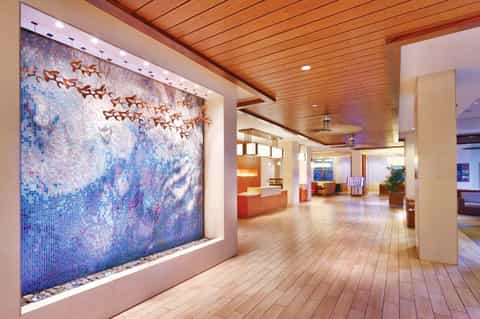 Modern spa interior with decorative mosaic tile wall feature and wooden ceiling in hallway