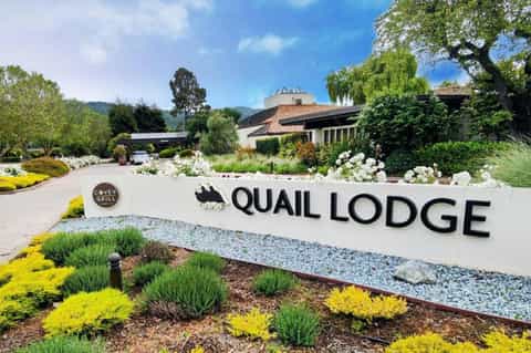 Quail Lodge resort entrance with manicured landscaping and mountain views