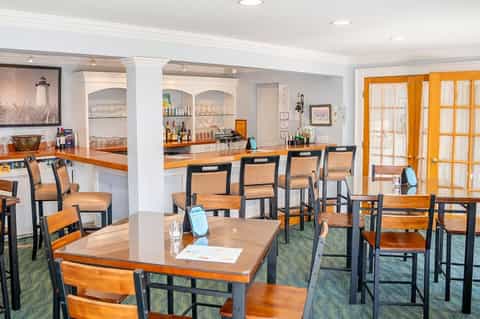 Casual dining area with wooden tables, bar counter, and orange accents