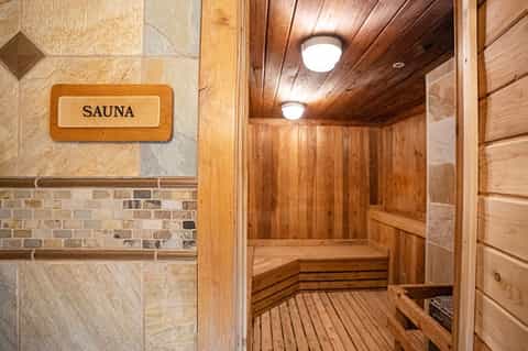Wooden sauna interior with cedar paneling, bench seating, and ambient lighting