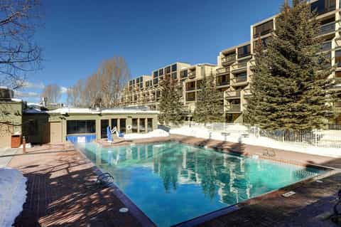 Outdoor swimming pool surrounded by tall residential buildings in winter