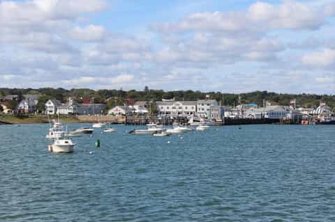 Coastal New England harbor town with moored boats and waterfront buildings