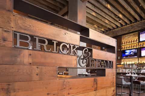 Brick and Beam restaurant entrance with rustic wooden signage and illuminated shelving