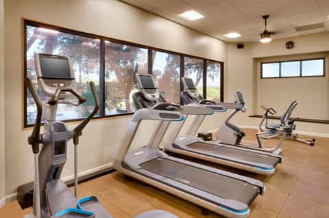 Modern fitness center with treadmills, exercise bikes and large windows