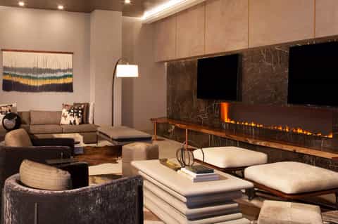 Contemporary living room with fireplace, neutral furnishings, and entertainment center with TV