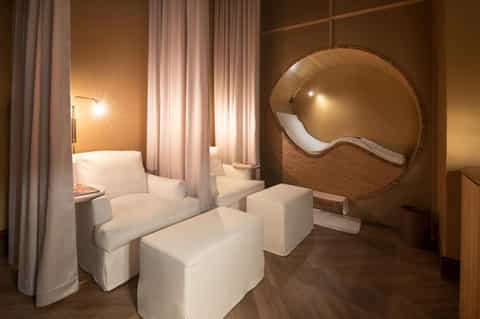 Spa relaxation room with modern wooden pod seating and warm ambient lighting