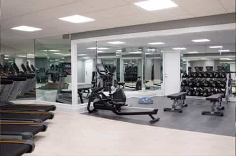 Modern fitness center with treadmills, stationary bikes, and mirrored walls