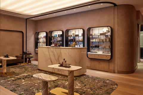 Luxury spa reception area with warm wood finishes, arched display cabinets, and marble countertops
