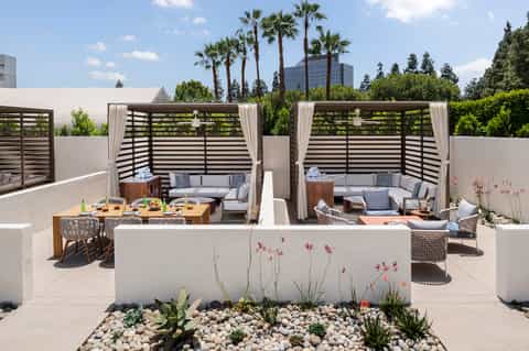 Modern rooftop terrace with lounge seating, dining area, and city skyline views
