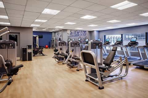 Modern fitness center with cardio machines, strength equipment, and motivational wall signage