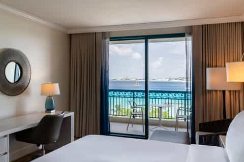 Oceanview hotel room with balcony, modern furnishings, and coastal landscape