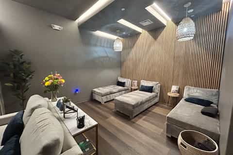 Contemporary multi-bed dormitory room with pendant lights, vertical wood paneling, and lounge seating