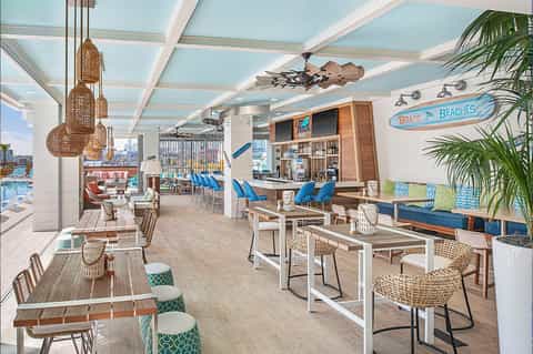 Beachfront casual dining area with striped ceiling, wooden accents, and blue coastal décor