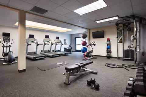 Fitness center with treadmills, exercise bikes, weights, and gym equipment
