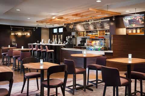 Modern hotel bar and lounge with wooden beams, dark wood accents, and contemporary seating