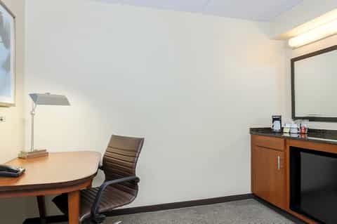 Hotel consultation room with desk, chair, mirror, and professional lighting