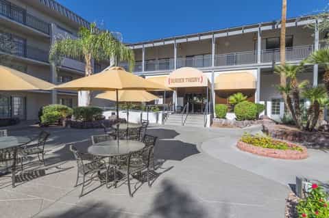 Hotel courtyard with outdoor dining area, umbrella-covered tables, and Burger Theory restaurant