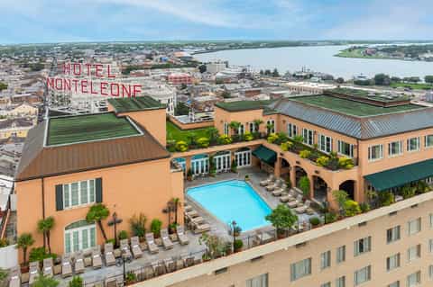 Aerial view of Hotel Monteleone with pool, green roofs, and river in background