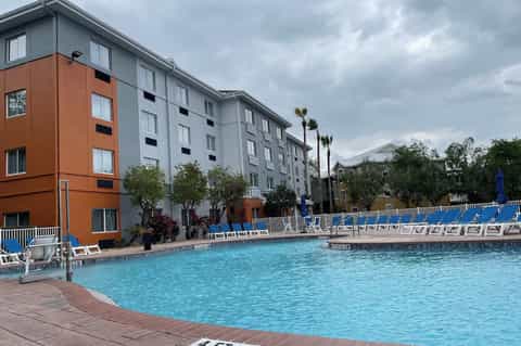 Resort complex with orange and gray modern buildings adjacent to bright turquoise pool
