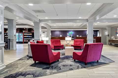 Hotel lobby with red velvet chairs arranged around tables near reception