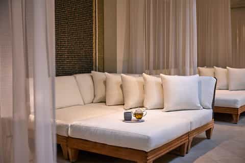 Luxury spa relaxation lounge with cream daybed and sheer curtains