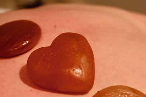 Close-up of red heart-shaped objects on coral pink sand surface
