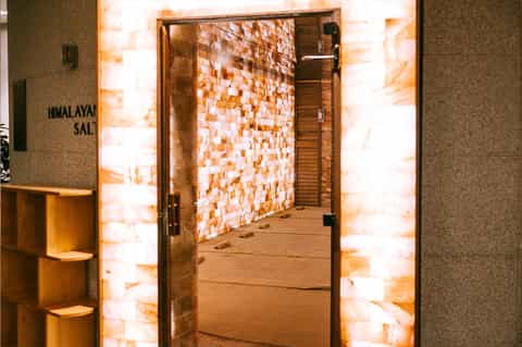Himalayan salt therapy room entrance with illuminated orange salt brick walls and wooden door