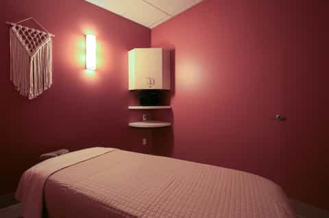 Minimalist bedroom with deep burgundy walls, white ceiling, bed, wall-mounted cabinet, and pendant light