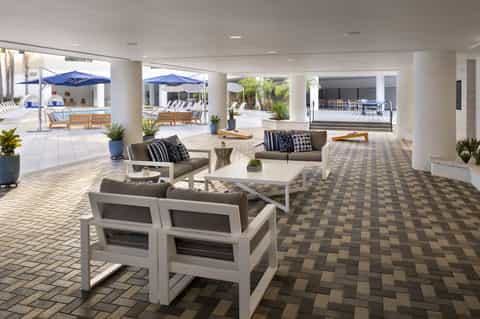 Covered patio area with comfortable seating, blue umbrellas, and ocean views