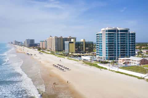 Beachfront resort with high-rise buildings, sandy beach, and ocean waves
