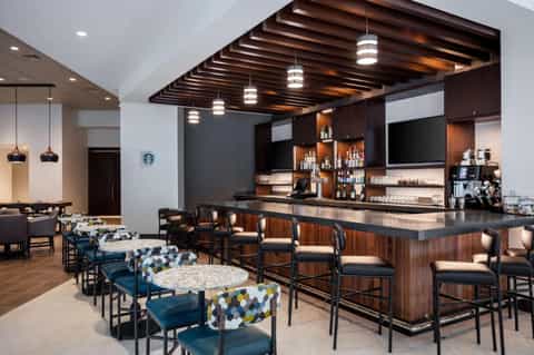 Modern resort bar and lounge with wood ceiling, dark wood bar counter