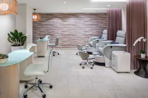 Modern spa salon interior with pedicure stations, wooden accents, and plants