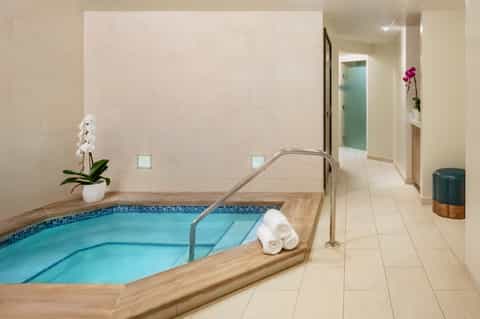 Indoor hot tub spa area with white tile walls and clean contemporary design