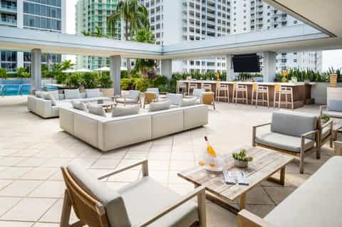 Multi-level resort terrace with lounge seating, bar counter, and swimming pool