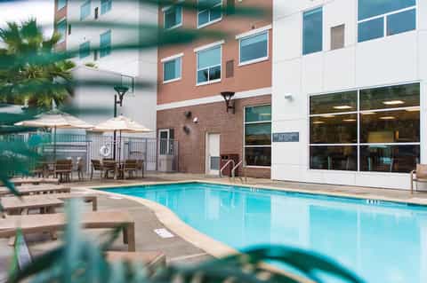 Indoor pool with brick accents, white pool deck, and large windows overlooking courtyard