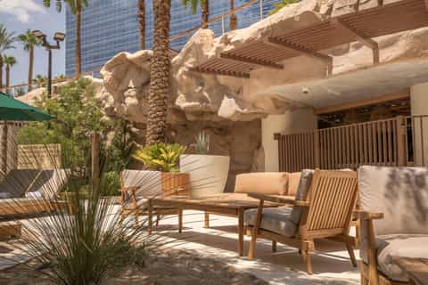 Outdoor patio seating area with modern furniture and desert rock formation