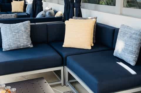 Modern outdoor seating area with dark blue cushioned benches and decorative pillows