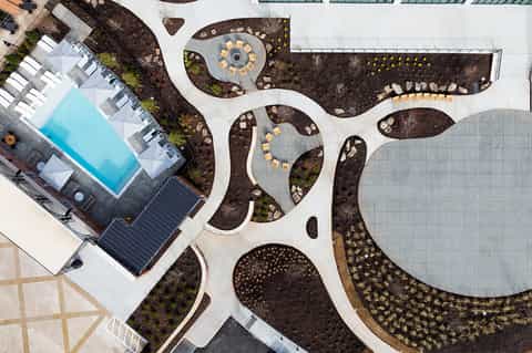 Aerial view of resort courtyard with curved pathways, pool, and landscaped seating areas
