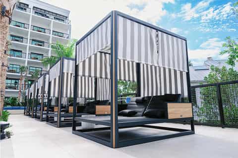 Contemporary black and white striped outdoor pavilion with black seating and wooden accents