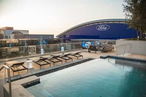Rooftop pool area with lounge chairs overlooking Ford Center arena