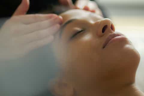 Close-up of woman receiving facial massage at spa