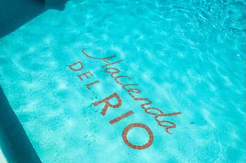Aerial view of hotel pool with 'Del Brisas' text inlaid in terracotta tiles on pool floor