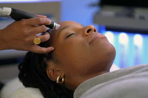 Spa treatment showing person receiving facial procedure with professional equipment