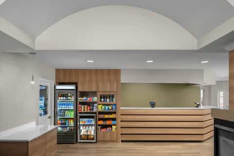 Modern hotel reception area with wooden elements, vending machines, and clean design