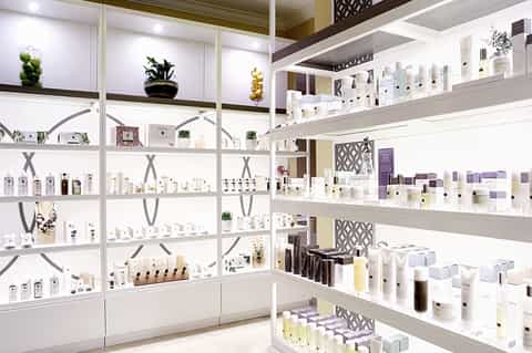 Bright spa retail display with shelves of beauty and wellness products organized on white cabinetry