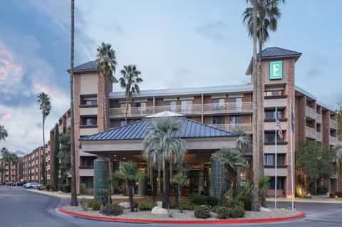 Brick hotel exterior with palm trees, ground-level entrance, and contemporary architectural design