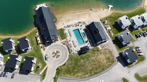Aerial view of beachfront resort with two main buildings, pool, and private beach access